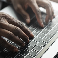 Woman typing on laptop keyboard