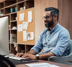 Man seated at laptop in an office setting