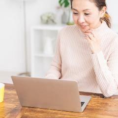 Woman smiling using laptop at desk